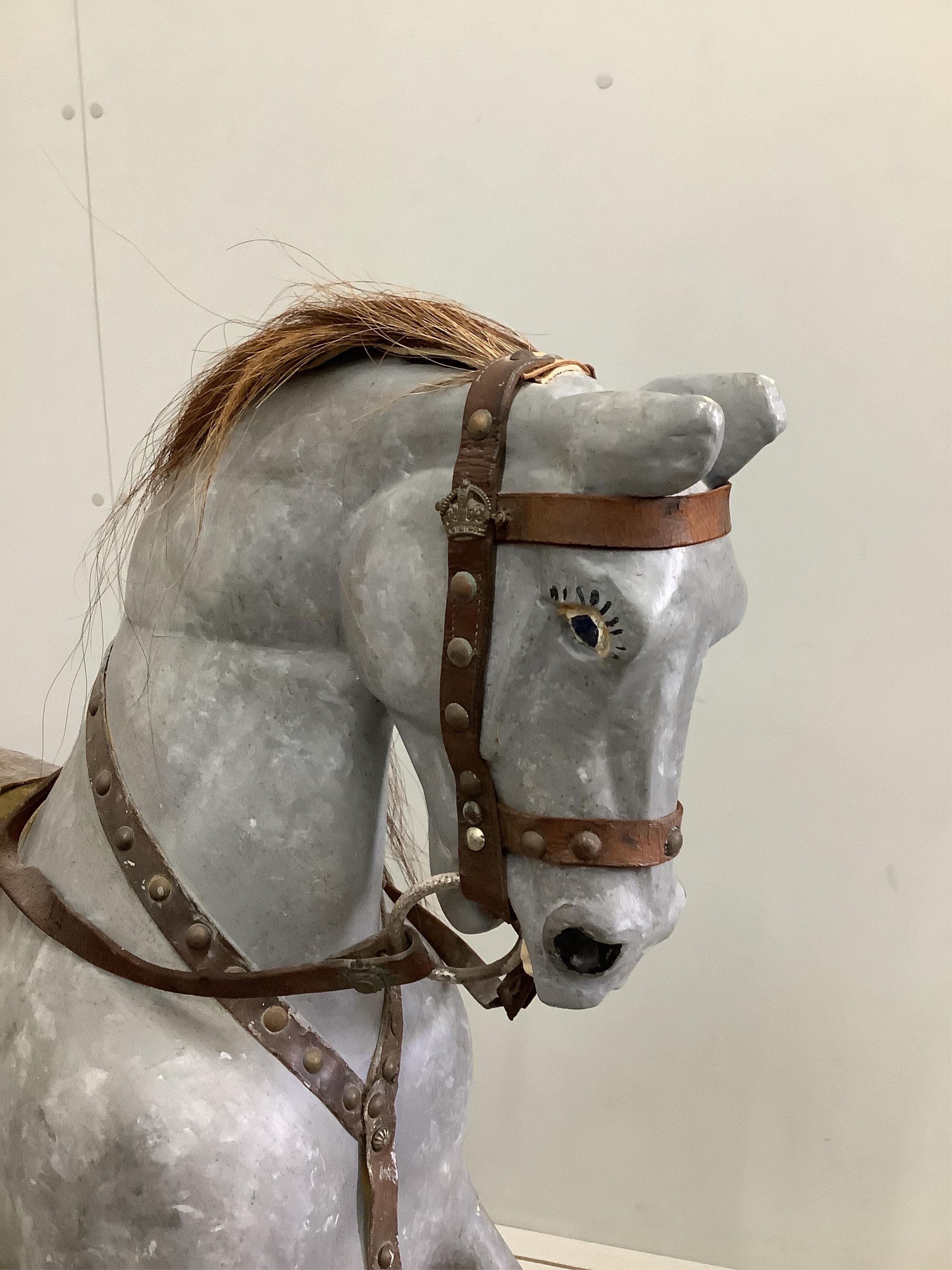 An early 20th century dapple grey rocking horse on pine safety frame, length 136cm, height 108cm. Condition - fair, later painted